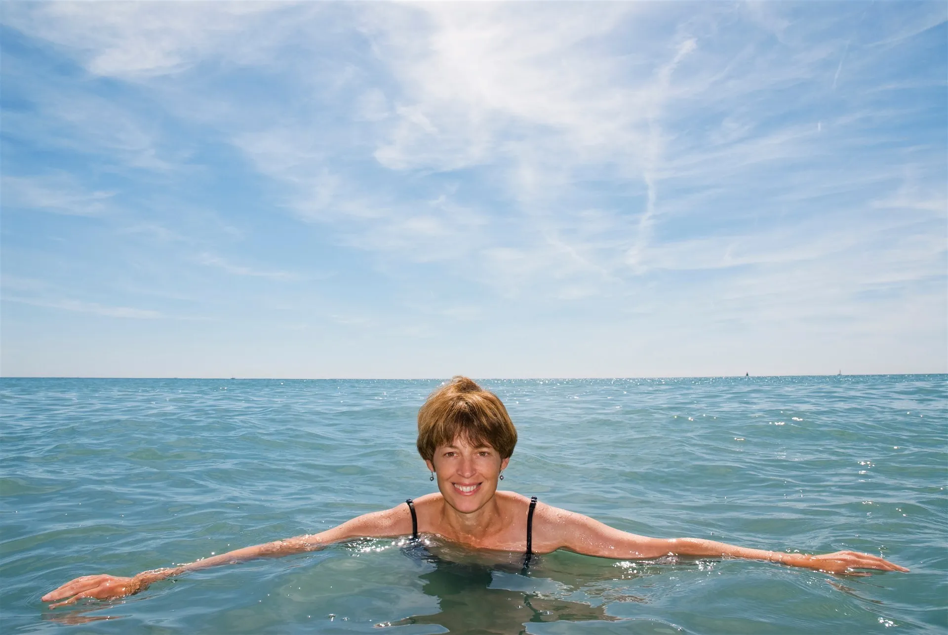 Midlife woman swimming in the sea on a sunny day
