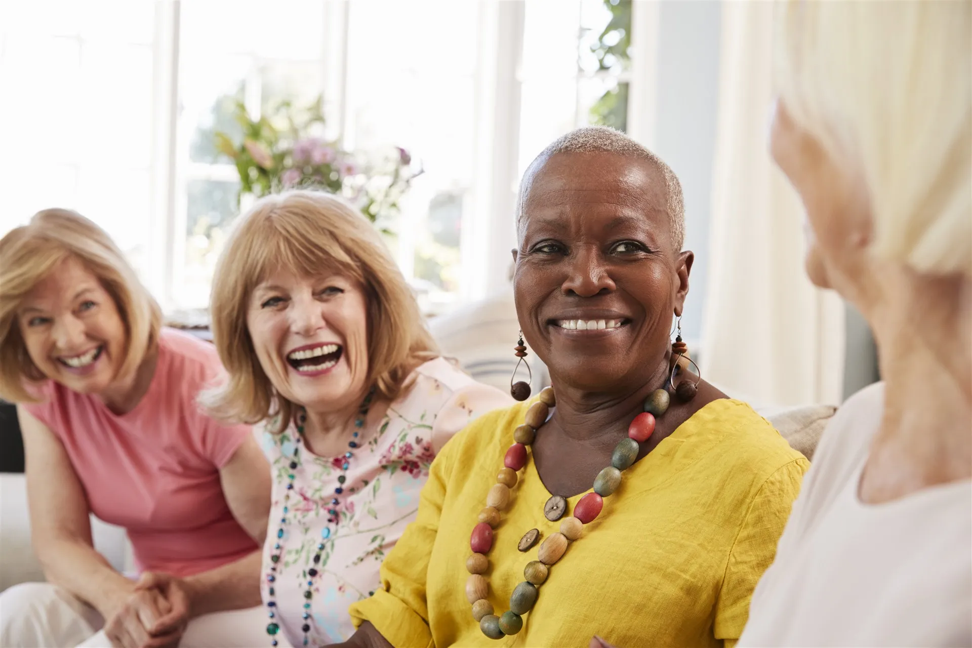 Group of women over 50 laughing together at home