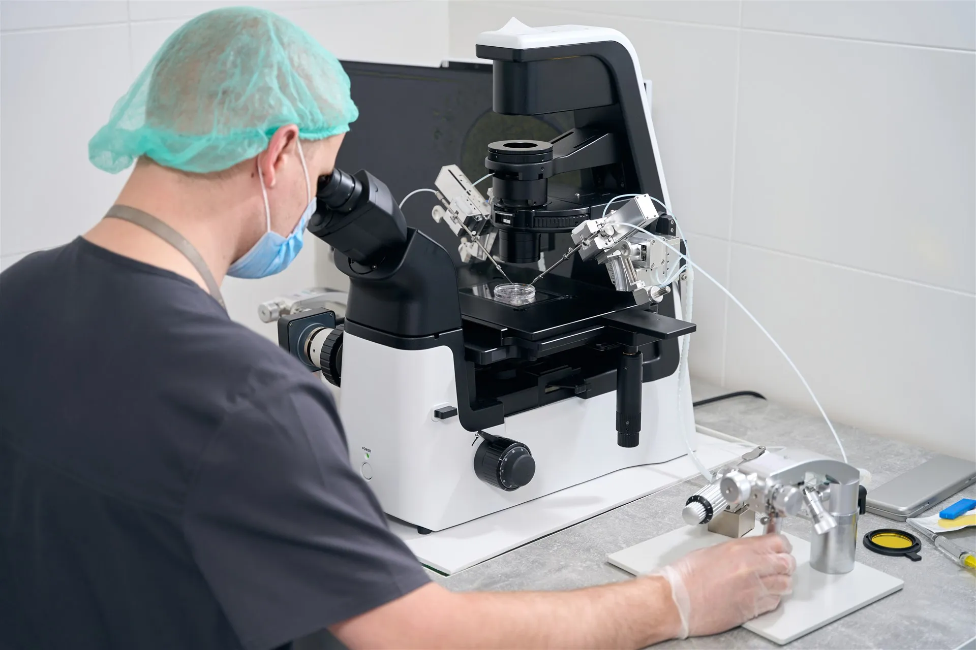 Embryologist working at a micromanipulation microscope in an IVF laboratory